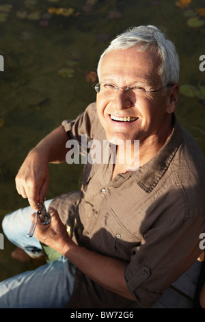 Senior man opening bottle of wine Stock Photo