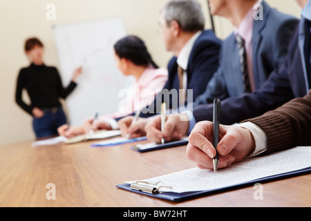 Row of business people making notes during presentation Stock Photo