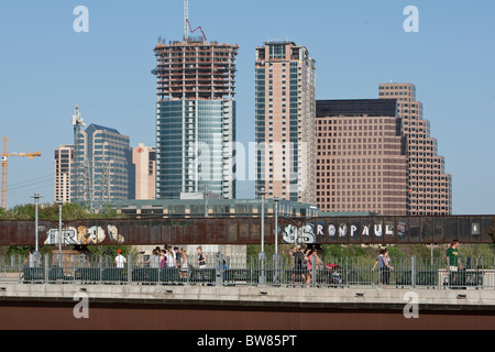 New condo construction in downtown Austin Texas. Graffiti-covered railroad bridge is in the foreground behind pedestrian bridge Stock Photo