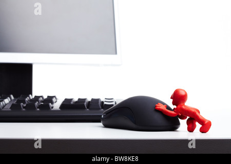 Image of plasticine man pushing computer mouse Stock Photo