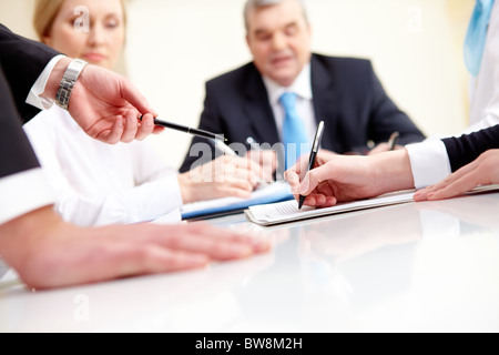 Close-up of business partners hands during planning in working environment Stock Photo