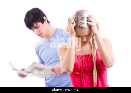 Stressed woman with touching her head on background of man reading paper Stock Photo