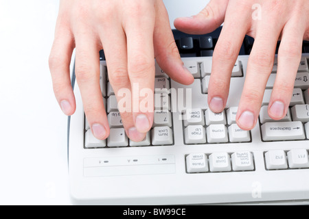 Above angle of male hands touching buttons of white computer keyboard Stock Photo