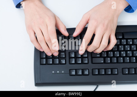 Close-up of male hand touching buttons of black computer keyboard Stock Photo