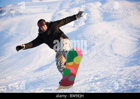 Image of brave man practicing snowboarding in winter Stock Photo