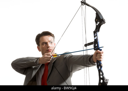 Portrait of concentrated male with crossbow in hands over white background Stock Photo
