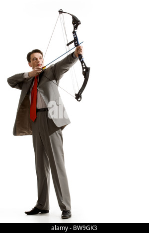 Portrait of courageous businessman holding crossbow and aiming at target Stock Photo