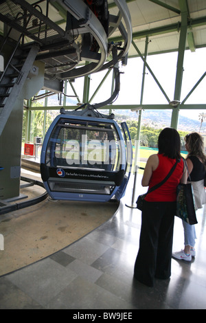 passengers waiting to board cable car as it moves round station.Funchal.Madeira Stock Photo