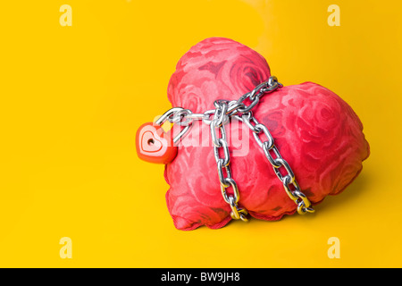 Creative image of soft toy heart bound with chain and small padlock Stock Photo