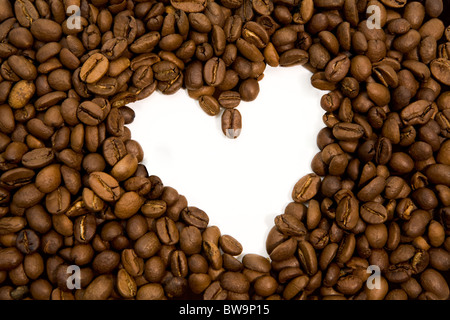 Image of coffee beans forming shape of heart on white background Stock Photo