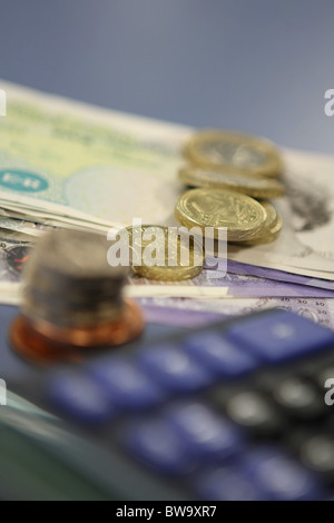 sterling notes and coins next to an out of focus calculator Stock Photo