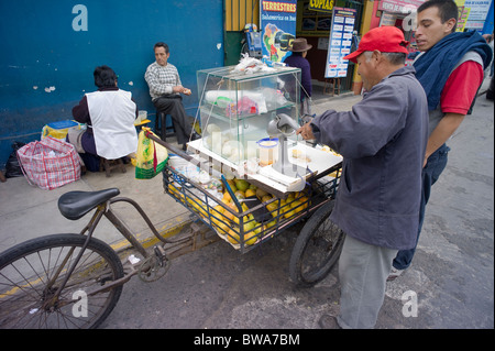 Man selling fresh squeezed orange juice from tricycle stand, Lima, Peru Stock Photo