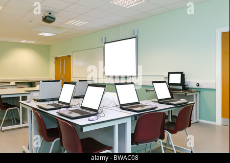 An IT classroom laptops on the desks and an interactive white board with blank screens to add your own image or text Stock Photo