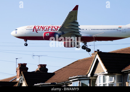 Heathrow runway rooftop approach by Airbus A330, Kingfisher Airlines, plane on approach low over houses for landing at London Heathrow Airport, UK. Stock Photo