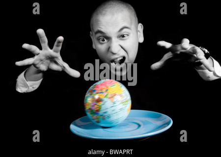 Furious man screaming while trying to capture earth rotating on blue saucer