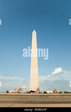 Friends lying down by washington monument Stock Photo