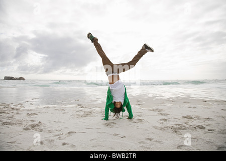 Young man doing cartwheels on beach Stock Photo