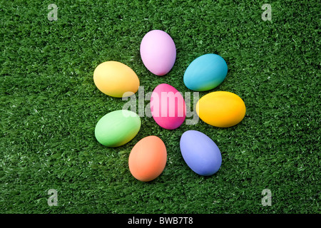 Photo of Easter eggs forming flower shape on green grass Stock Photo
