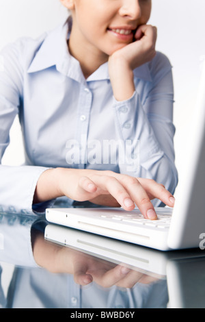 Image of smiling female pressing laptop buttons at work Stock Photo