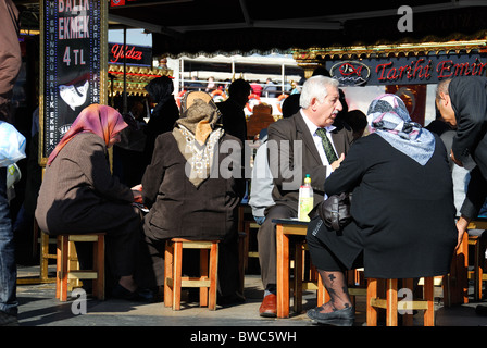 ISTANBUL, TURKEY. People sitting at a balik ekmek (mackerel sandwich) stall on the Golden Horn in Eminonu district. 2010. Stock Photo