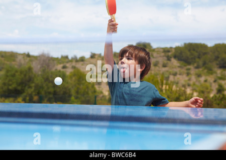 Young boy playing table tennis outdoors Stock Photo
