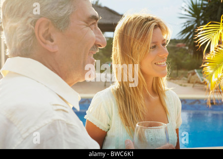 Smiling man and woman by poolside Stock Photo