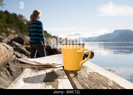 Coffee and paper,woman in background Stock Photo