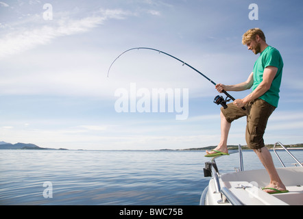 Man deep-sea fishing from boat Stock Photo