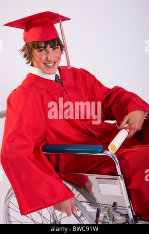 Male graduate student in wheelchair, holding diploma and smiling, portrait Stock Photo