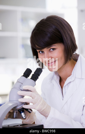 Female scientist using microscope in laboratory, portrait Stock Photo