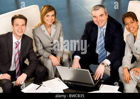 Portrait of several successful employees looking at camera and smiling Stock Photo