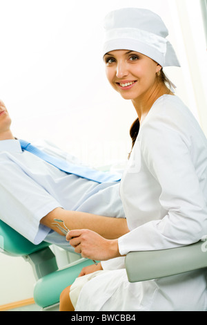 Portrait of young professional looking at camera on background of patient Stock Photo