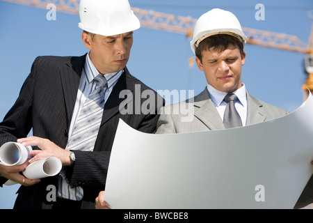 Portrait of two architects looking at project on construction site Stock Photo