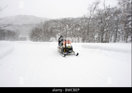 Man riding a snowmobile at Hanazono resort in Niseko, Hokkaido northern Japan. Stock Photo