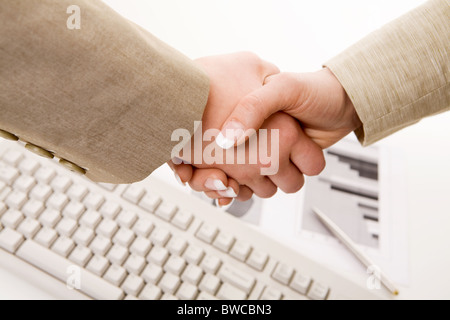 Photo of handshake of business partners after striking deal on background of keyboard Stock Photo