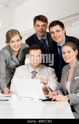 Portrait of several successful co-workers looking at camera with smiles at workplace Stock Photo