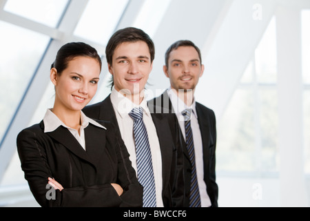 Portrait of confident co-workers standing in line with pretty employer in front Stock Photo