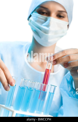 Laboratory worker selecting flasks with analyses while holding one containing red fluid inside Stock Photo