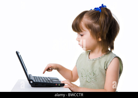 Profile view of serious preschooler going to push Enter button on laptop keyboard Stock Photo