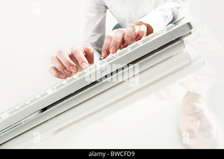 Photo of secretary’s hands over computer keyboard with her reflection near by Stock Photo