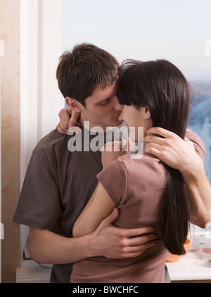 Russia, Voronezh, Young couple embracing in kitchen Stock Photo