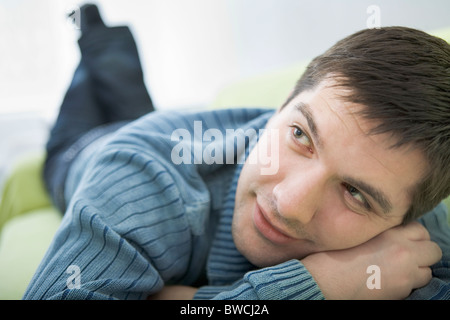 Russia, Voronezh, Young man resting on bed Stock Photo