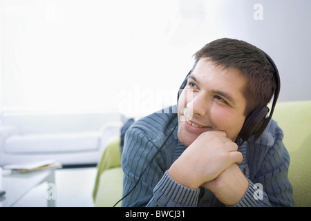 Russia, Voronezh, Young man lying on bed and listening music Stock Photo