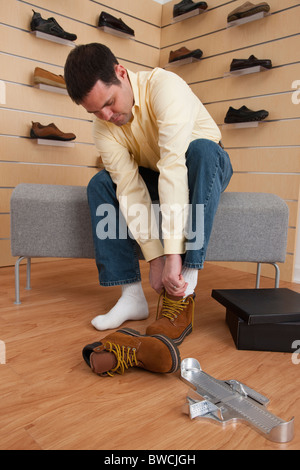 USA, Illinois, Metamora, Man trying on hiking boots in store Stock Photo