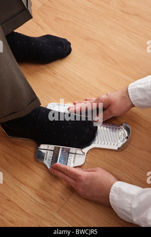 USA, Illinois, Metamora, Close up of sales clerk measuring man's foot at shoes store Stock Photo