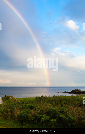 A rainbow at sunset over the Kilbrannan Sound, east of the Kintyre peninsula, from near Peninver, Argyll & Bute, Scotland Stock Photo
