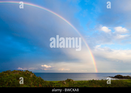 A rainbow at sunset over the Kilbrannan Sound, east of the Kintyre peninsula, from near Peninver, Argyll & Bute, Scotland Stock Photo