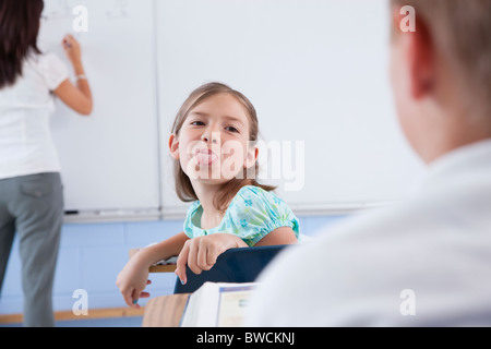 USA, Illinois, Metamora, Teacher and students (8-9) in classroom, girl showing tongue Stock Photo