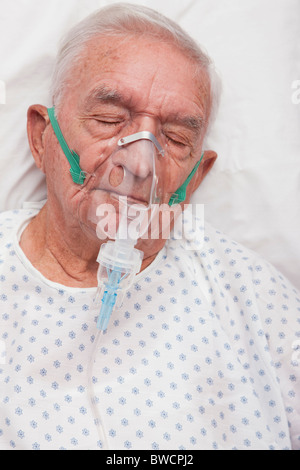 USA, Illinois, Metamora, Senior man with oxygen mask sleeping in hospital bed Stock Photo
