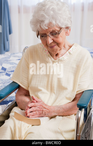 USA, Illinois, Metamora, Senior woman on wheelchair praying Stock Photo